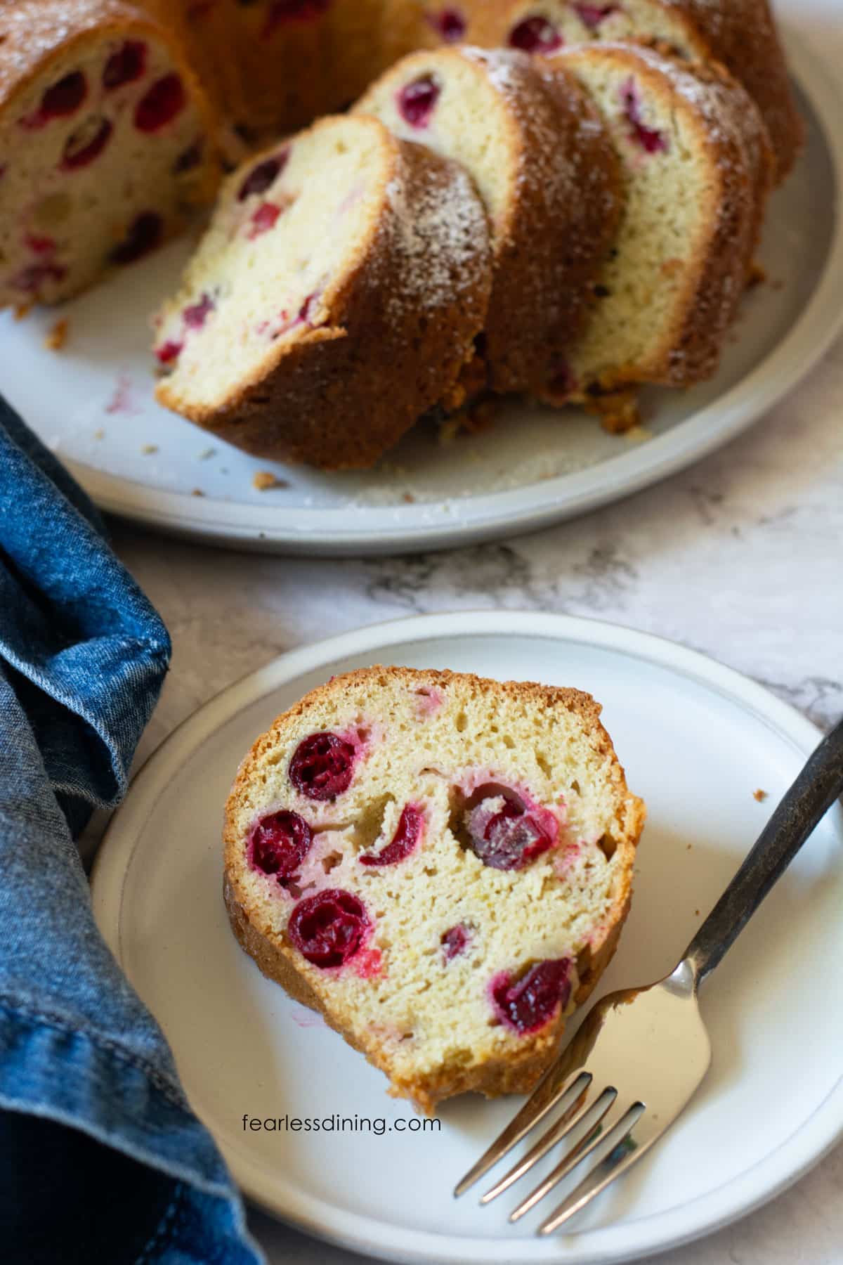 The top view of a slice of cranberry bundt cake on a small white plate.