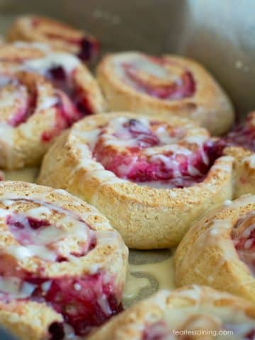 A close up of the baked gluten free cranberry rolls topped with glaze.