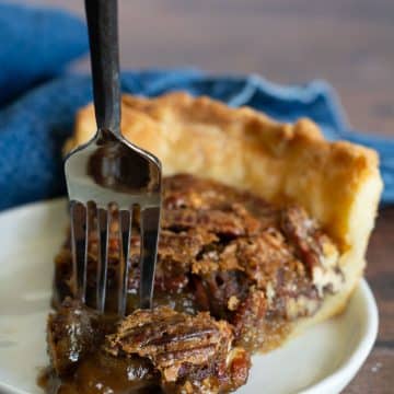 Inserting a fork into a slice of pecan pie.