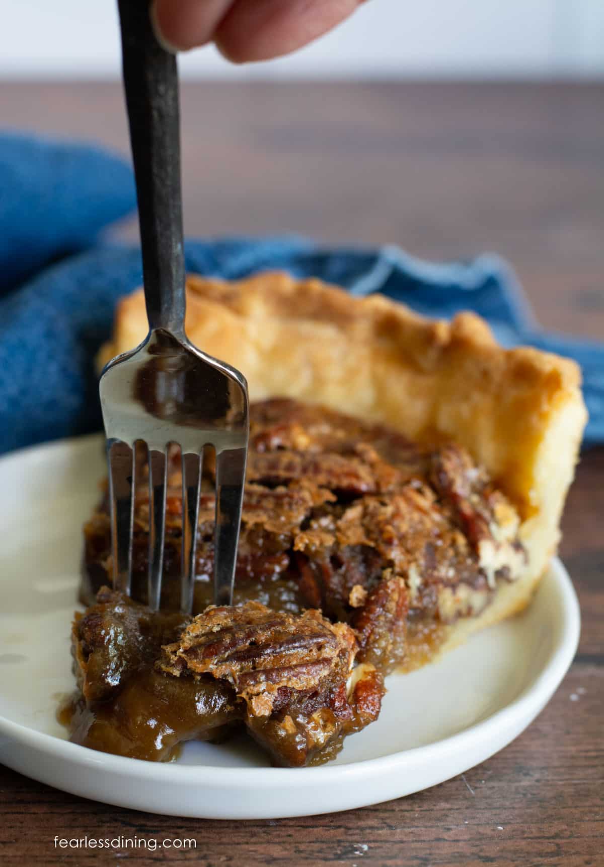 Inserting a fork into a slice of pecan pie.