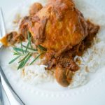 A serving of the crock pot chicken over rice on a white plate.