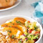 Pineapple chicken over rice in a bowl.