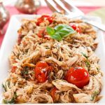 A rectangular platter filled with shredded chicken.