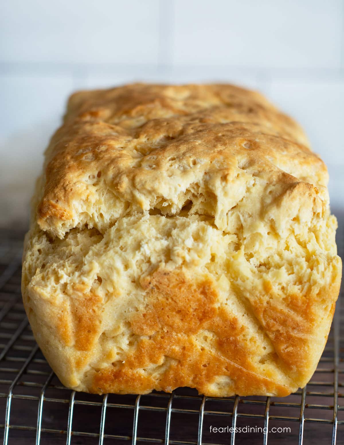 The front view of a baked loaf of gluten free no yeast bread on a wire rack.