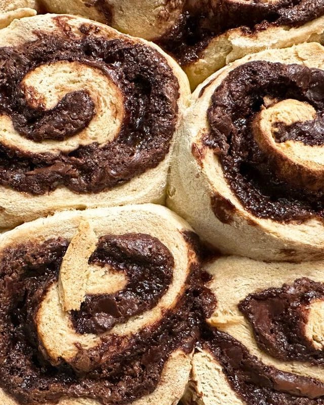 A close up of the baked gluten free nutella cinnamon rolls in a pan.