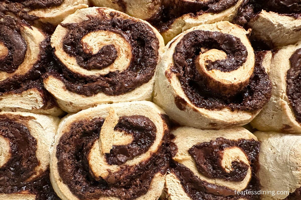 A close up of the baked gluten free nutella cinnamon rolls in a pan.