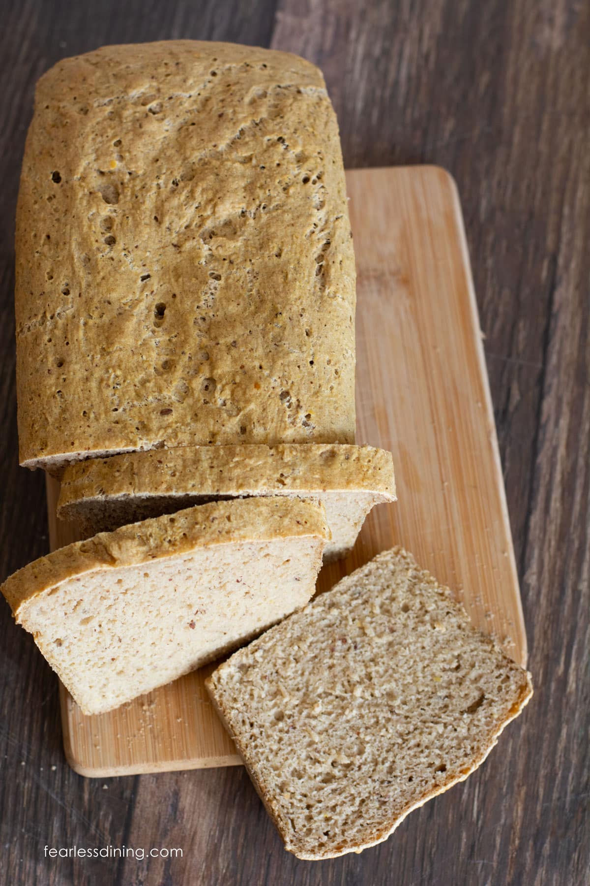 A top view of a sliced loaf of bread on a wooden cutting board.