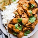 A plate with slow cooker butter chicken and white rice.