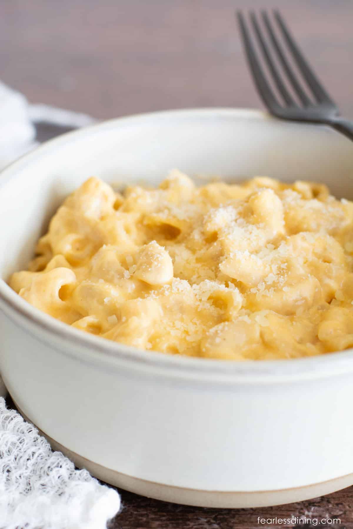 A bowl full of crock pot gluten free mac and cheese. A fork is on the edge of the bowl.