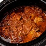 Cooked spicy chicken thighs in a slow cooker.