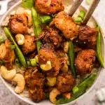 a bowl full of slow cooker cashew chicken over rice.