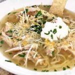 A bowl of the white bean chicken soup garnished with sour cream.