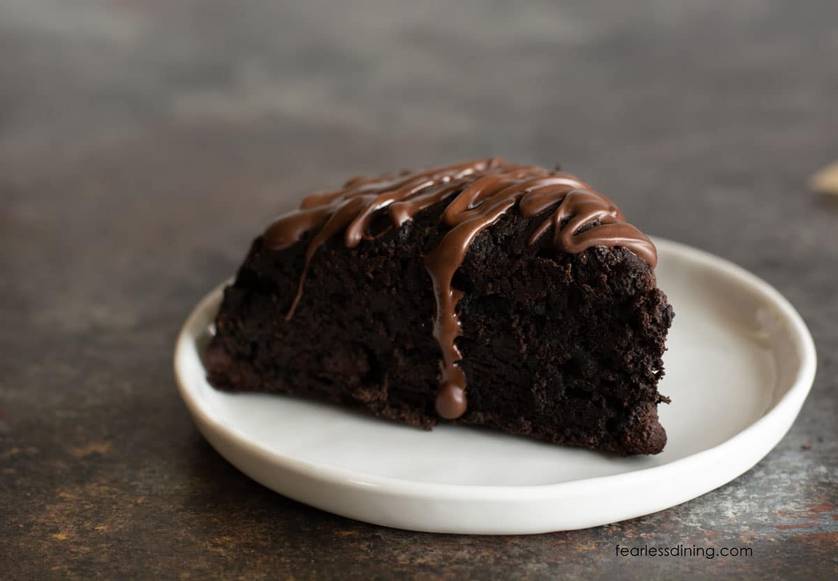 A chocolate scone on a small white plate.