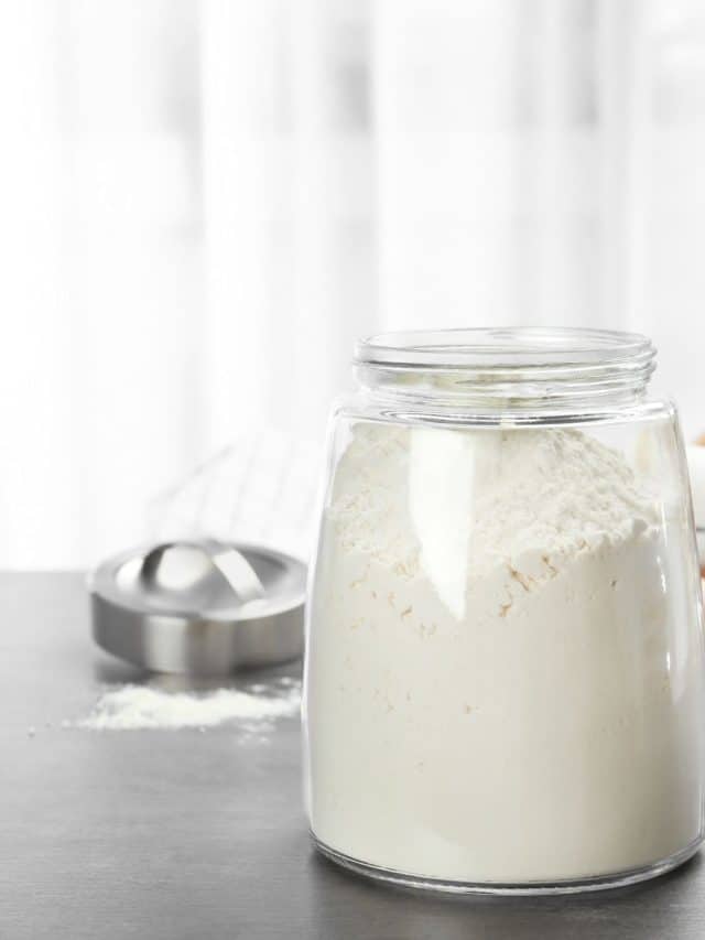 A mason jar filled with gluten free flour sitting on the counter.