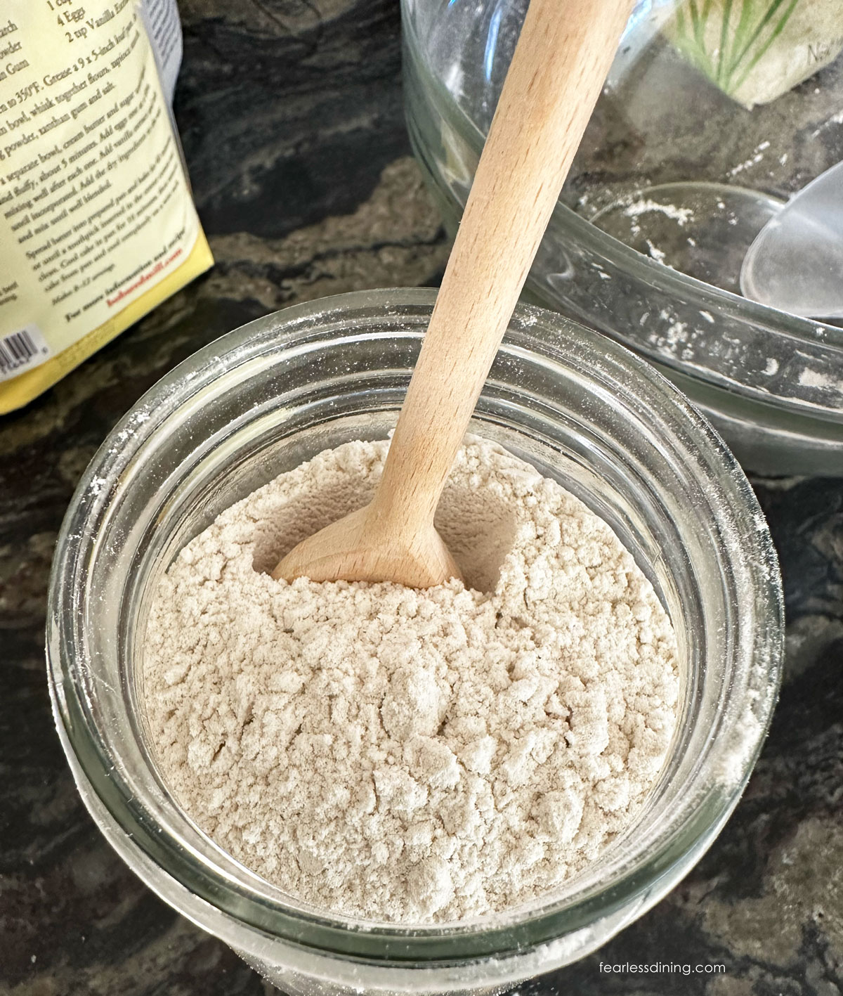 Scooping the gluten free whole grain flour in the large mason jar.