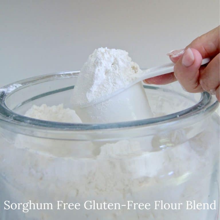 Scooping gluten-free sorghum-free flour out of a large jar.