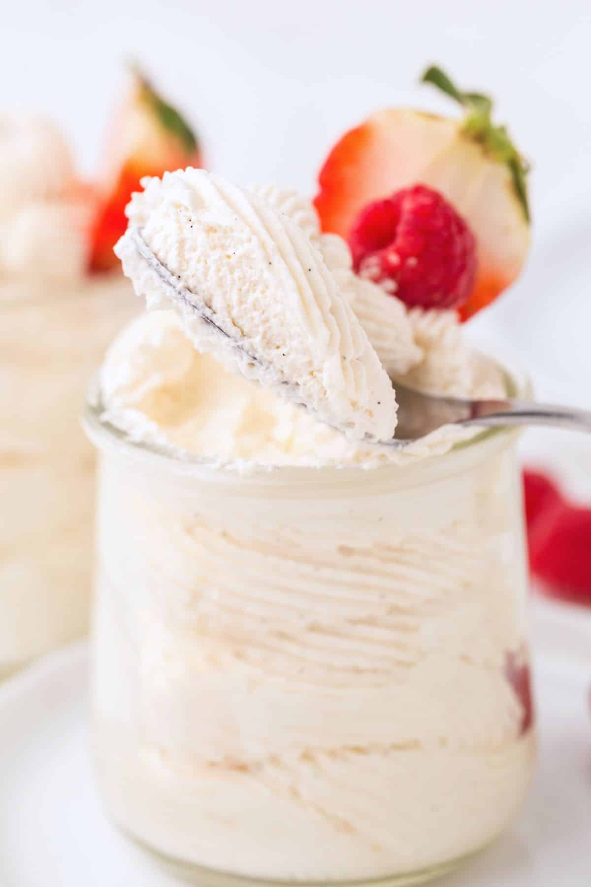 A spoon holding up a bite of the thick vanilla mousse.