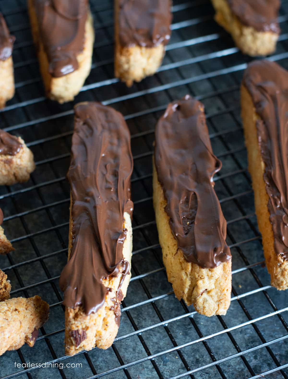 Chocolate covered almond biscotti on a wire rack.