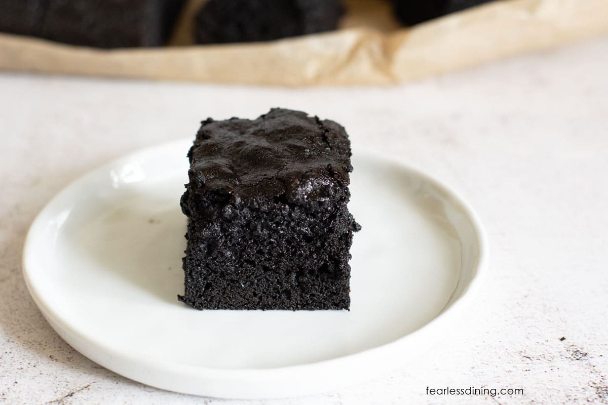 A gluten free espresso brownie on a small white plate.