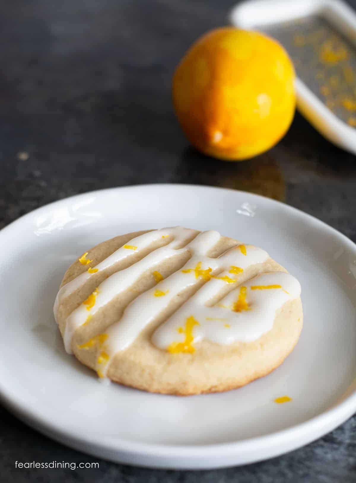 A gluten free lemon shortbread cookie topped with lemonade icing and lemon zest.