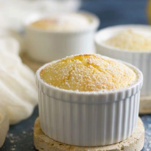 Three gluten free lemon sour cream cakes in white ramekins.