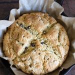 A baked Irish soda bread loaf in a cast iron skillet.