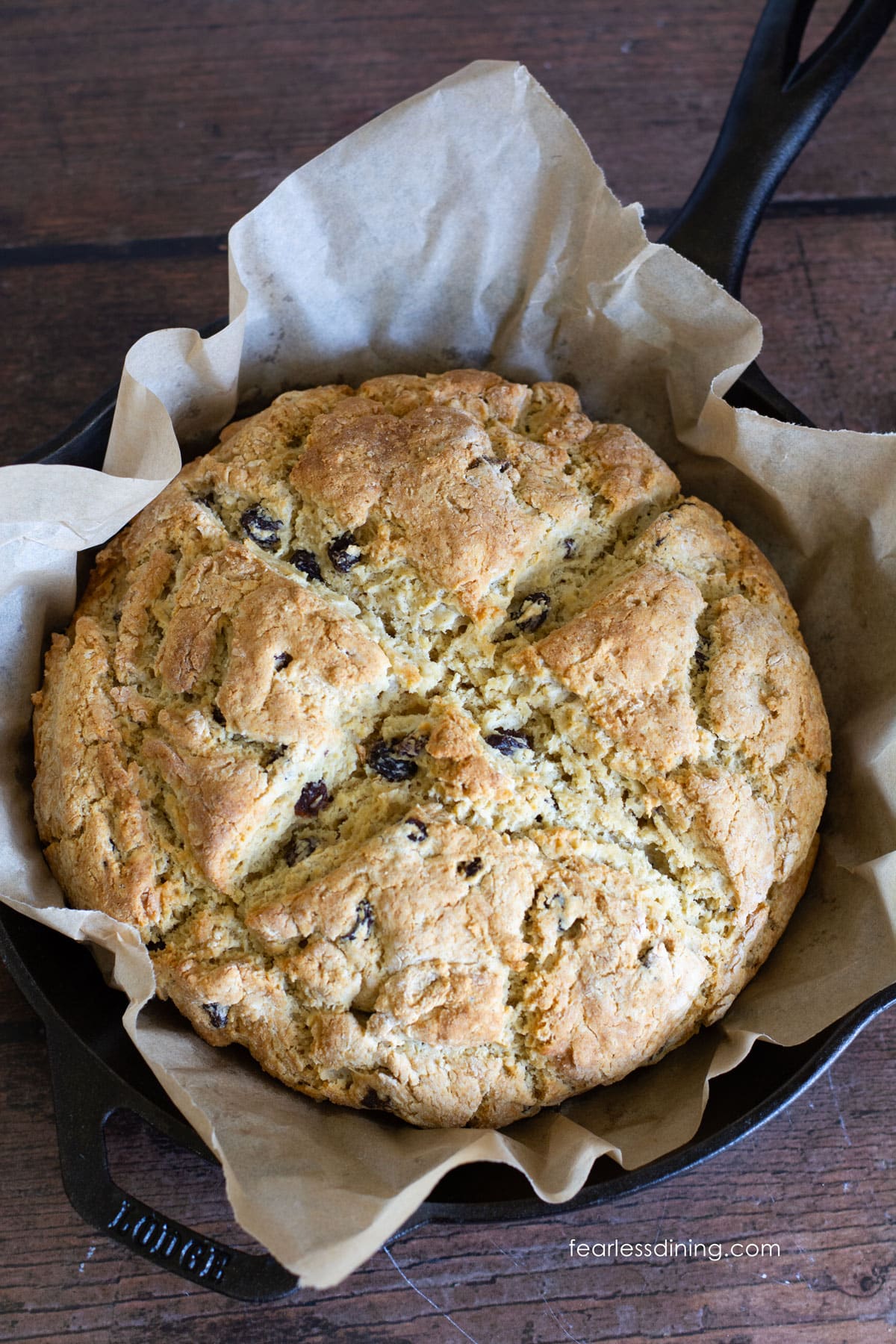 A baked Irish soda bread loaf in a cast iron skillet.