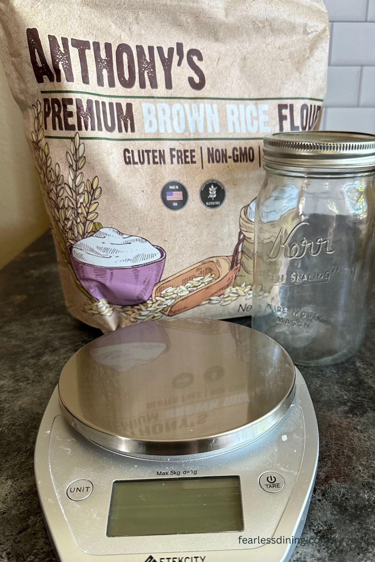 A photo of brown rice flour, a wide mouth mason jar, and a digital scale.