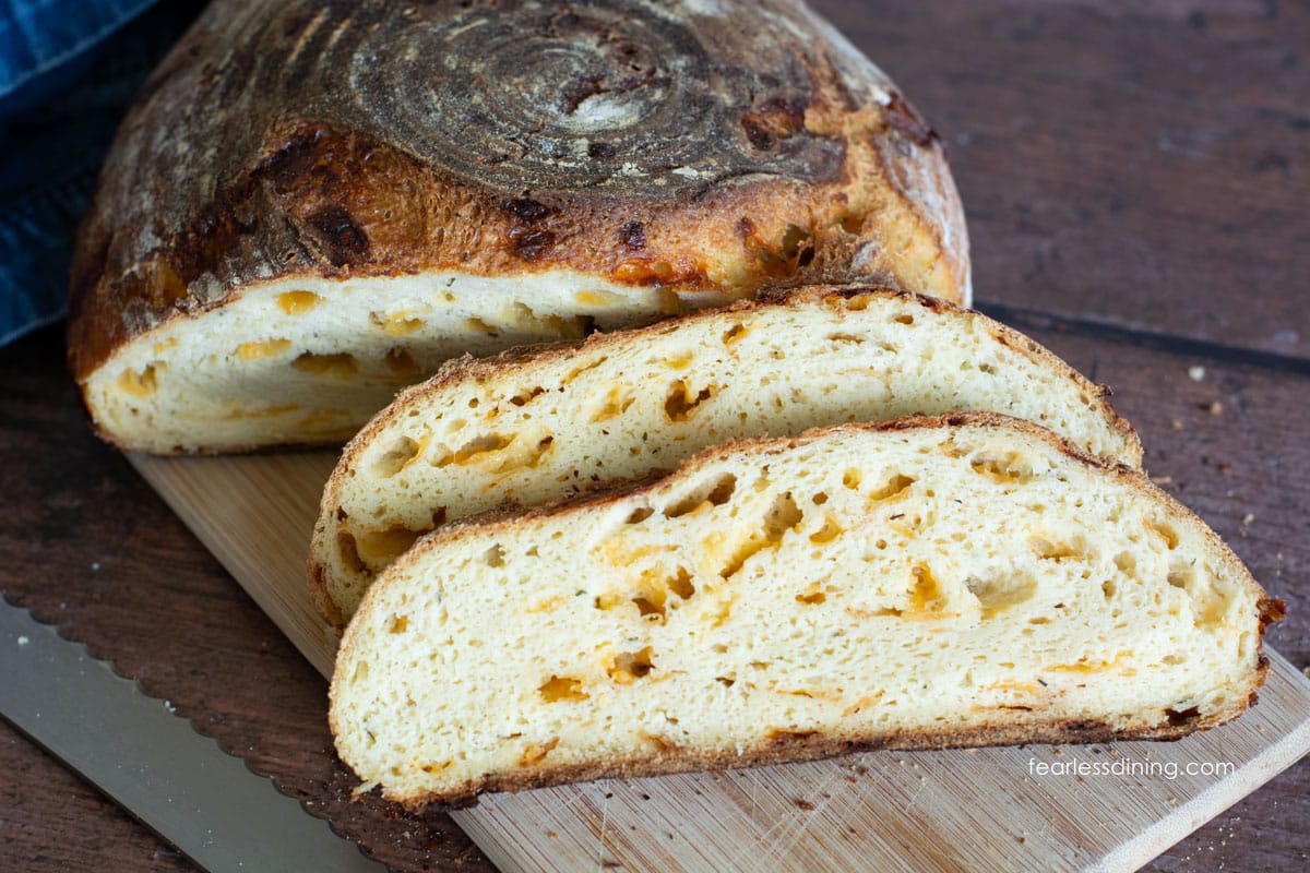 Slices of gluten free cheddar sourdough bread on a cutting board.