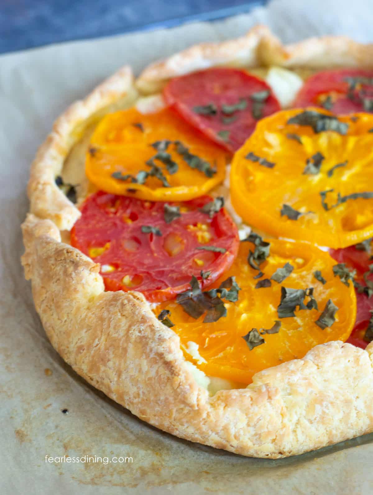 A close up of the gluten free tomato galette on a baking sheet.