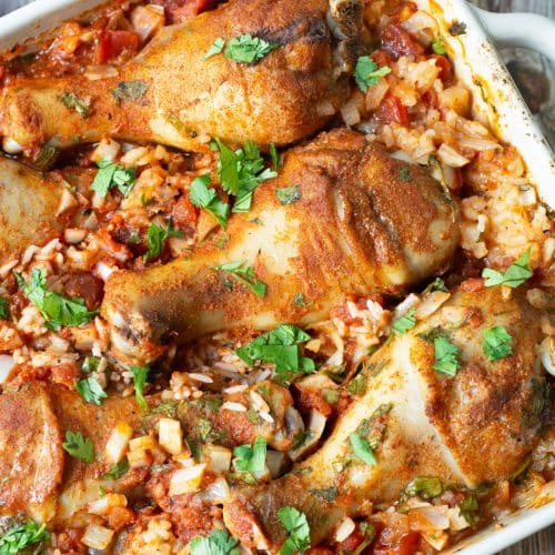 An 8x8 casserole dish filled with baked Mexican Chicken and Rice.