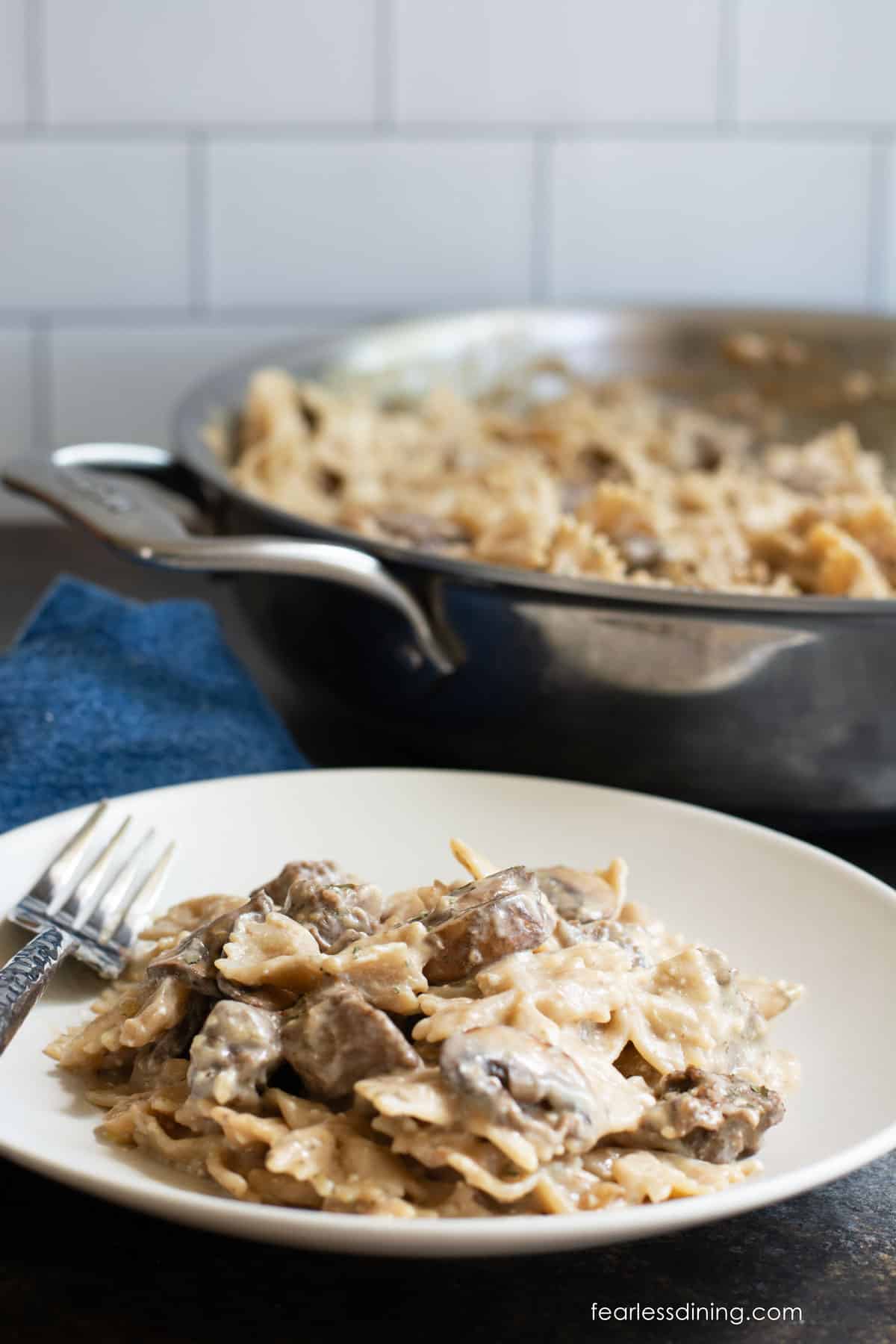The plate of beef stroganoff next to the pan on the counter.