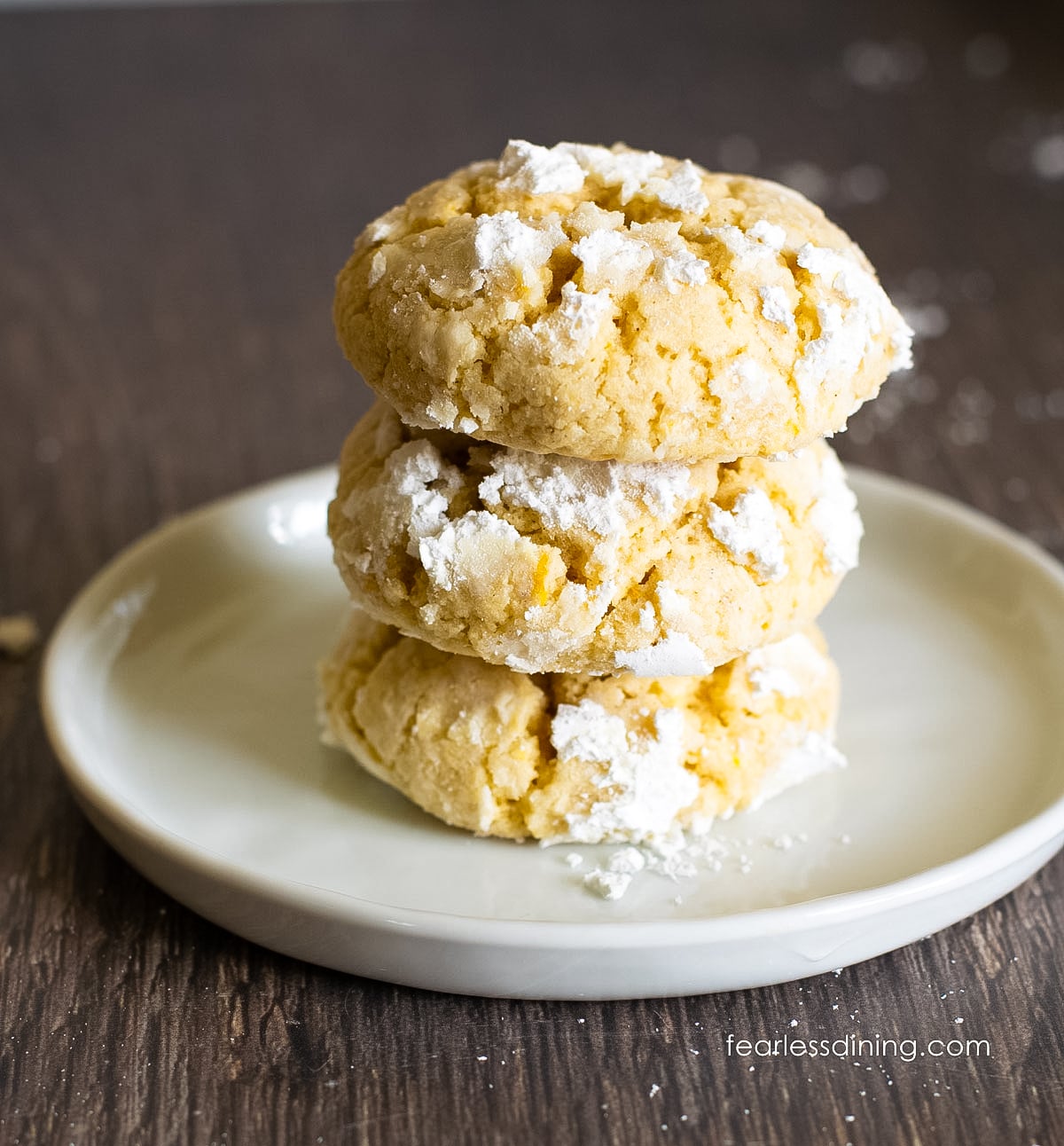 A stack of three gluten free lemon crinkle cookies.
