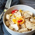 A bowl full of cajun chicken pasta on a table.
