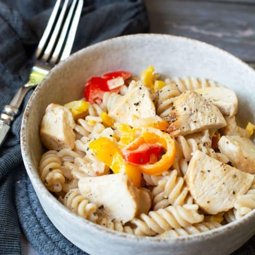 A bowl full of cajun chicken pasta on a table.