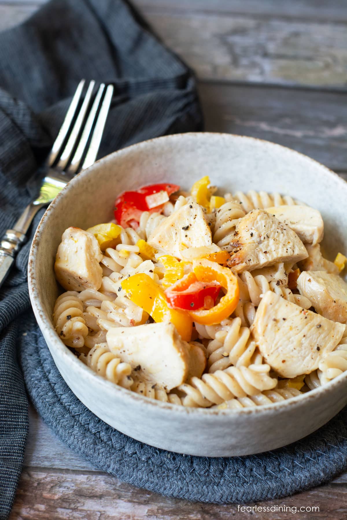 A bowl full of cajun chicken pasta on a table.