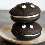 Two gluten free black velvet whoopie pies stacked on top of each other. They have googly eyes.