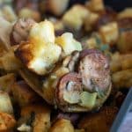 A close up of the stuffing on a large serving spoon.