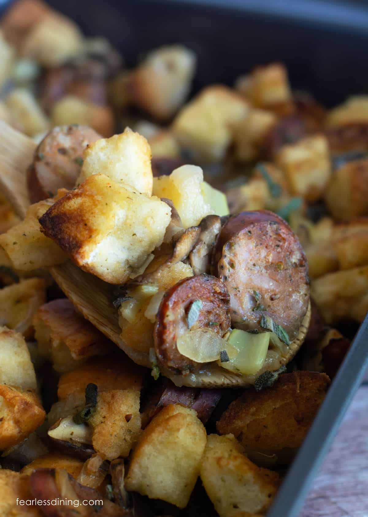 A close up of the stuffing on a large serving spoon.