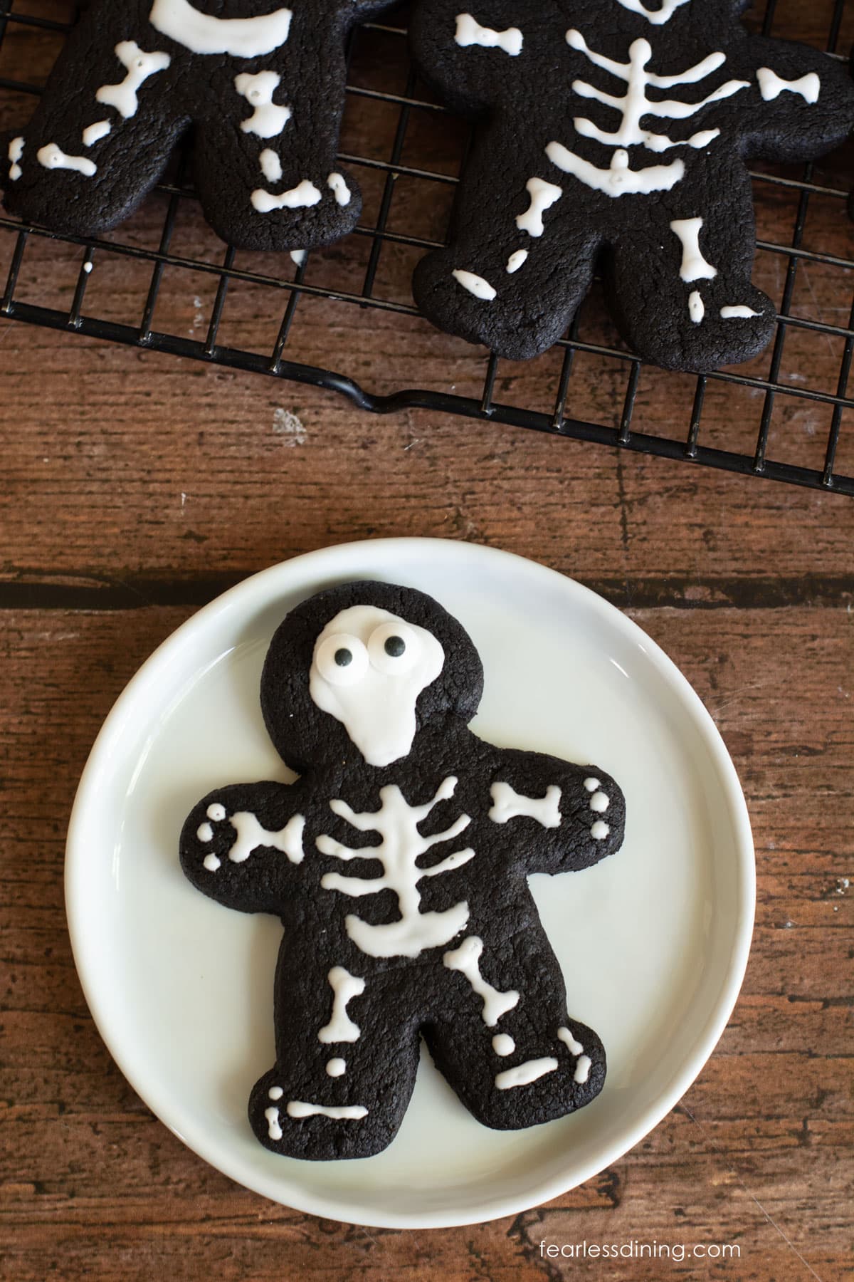A gluten free skeleton cookie on a small white plate.