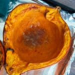 Half of a kuri squash roasted on an oven pan.