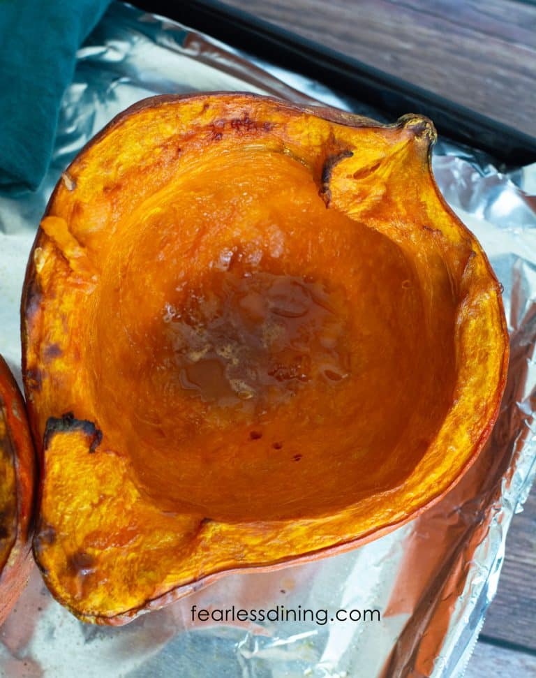 Half of a kuri squash roasted on an oven pan.