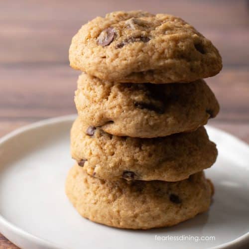 A stack of four gluten free eggnog chocolate chip cookies on a plate.