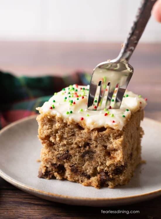 Pushing a fork into a slice of cake to get a bite.