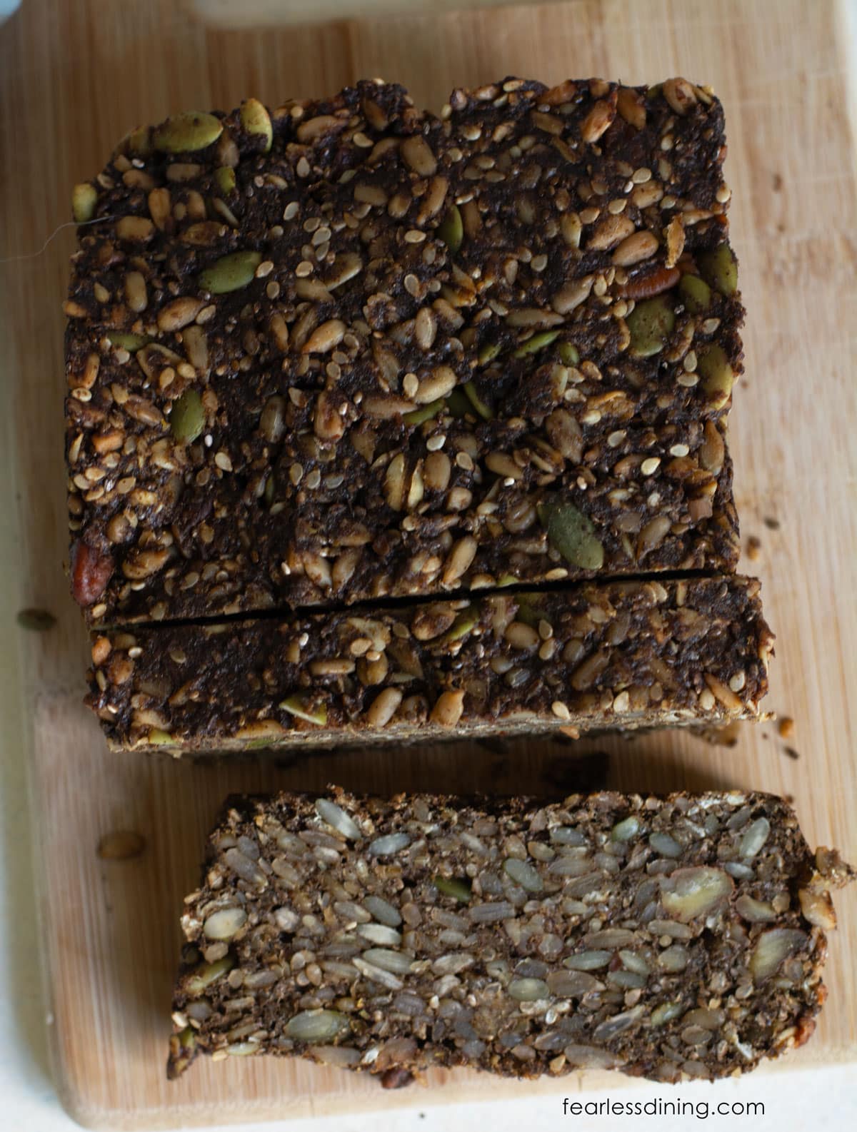 The top view of a loaf of seeded brown bread.