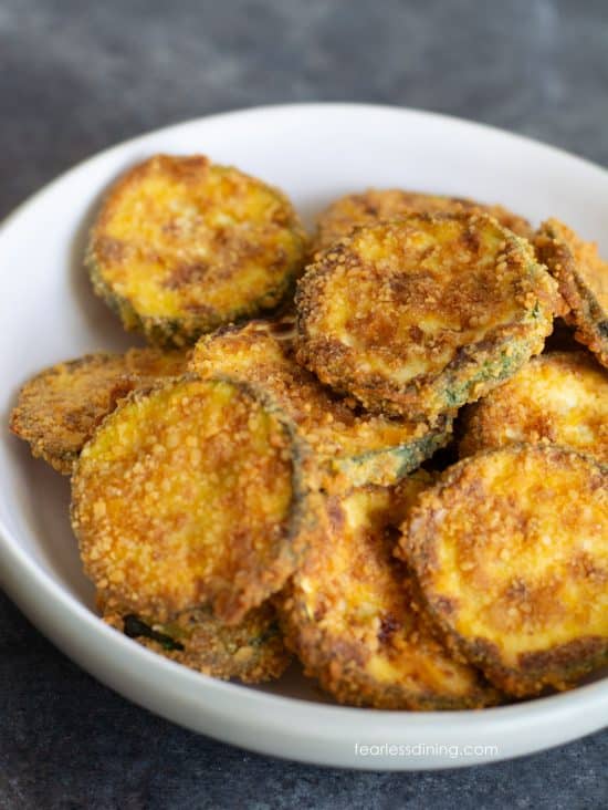A bowl of crisp gluten free air fryer zucchini chips.