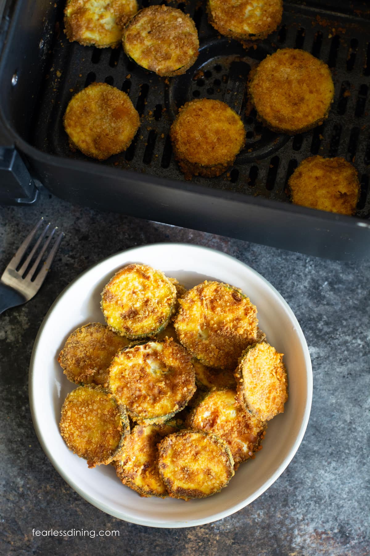 A photo of a small bowl filled with fried zucchini chips.