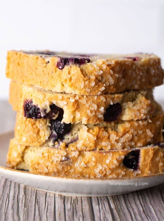 A stack of four slices of gluten-free lemon bread with sourdough discard on a small plate.
