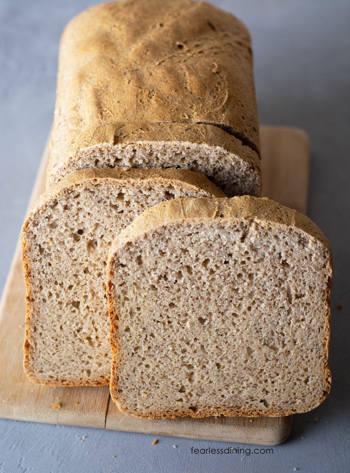 Slices of bread next to the loaf on the cutting board.