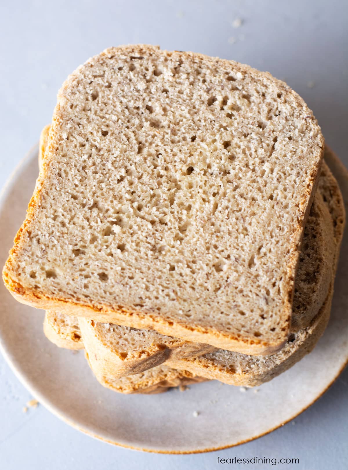 The top view of several slices of gluten free bread on a white plate.